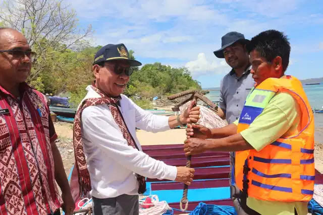 Bupati Kupang, Korinus Masneno saat menyerahkan 10 unit perahu motor kepada 20 kelompok.penerima bantuan di 4 desa di Kecamatan Semau, Jumat (21/10/2022)